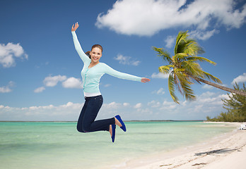 Image showing smiling young woman jumping in air