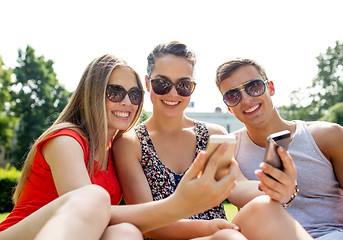 Image showing smiling friends with smartphone making selfie