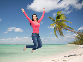 Image showing smiling young woman jumping in air