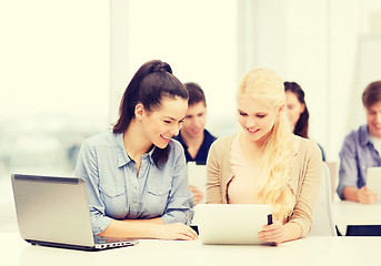 Image showing two smiling students with laptop and tablet pc