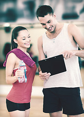 Image showing smiling male trainer with woman in the gym