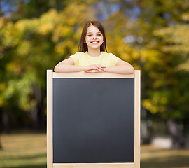 Image showing happy little girl with blank blackboard