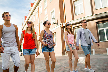 Image showing group of smiling friends walking in the city