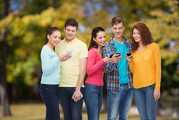 Image showing group of smiling teenagers with smartphones