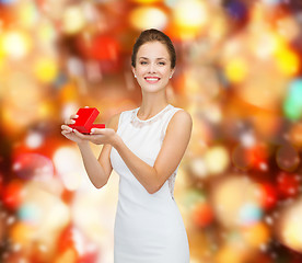 Image showing smiling woman holding red gift box