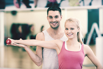 Image showing male trainer with woman working out with dumbbell