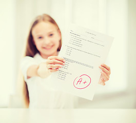 Image showing smiling little student girl with test and A grade