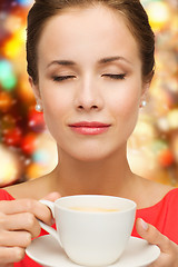 Image showing smiling woman in red dress with cup of coffee