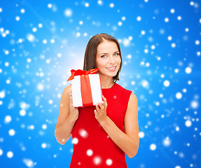 Image showing smiling woman in red dress with gift box