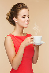 Image showing smiling woman in red dress with cup of coffee