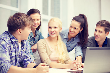 Image showing group of smiling students with laptop at school