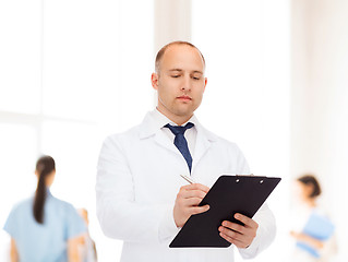 Image showing serious male doctor with clipboard