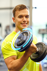 Image showing smiling man with dumbbell in gym