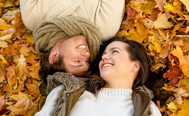 Image showing close up of smiling couple lying in autumn park