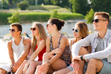 Image showing group of smiling friends sitting on city square