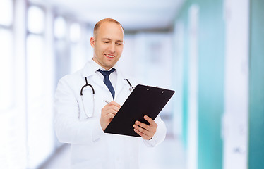 Image showing smiling male doctor with clipboard and stethoscope