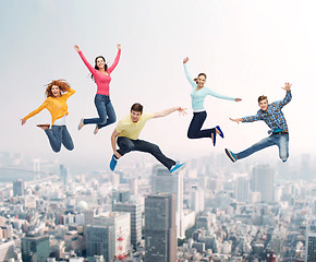 Image showing group of smiling teenagers jumping in air