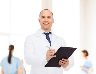 Image showing smiling male doctor with clipboard