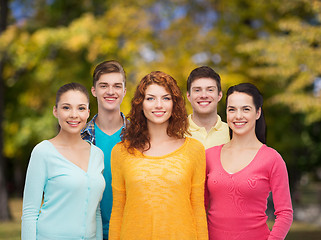 Image showing group of smiling teenagers over green park