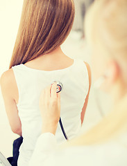 Image showing doctor with stethoscope listening to child back