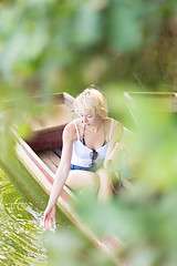 Image showing Woman relaxing on the vintage wooden boat.