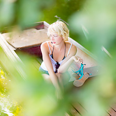 Image showing Thoughtful woman on the vintage wooden boat.