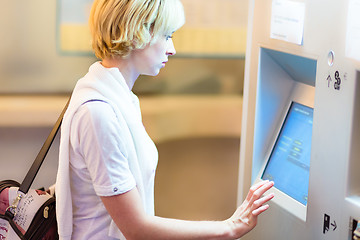 Image showing Lady using ticket vending machine.