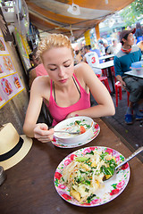 Image showing Traveler eating traditional thai Tom Yum soup.