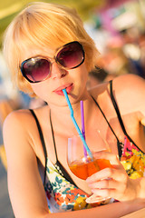 Image showing Cute young lady  drinking cocktail.