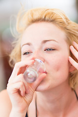 Image showing Lady having a shot of spirit drink.