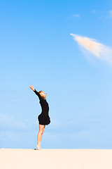 Image showing Playful girl throwing sand in the air.