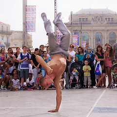 Image showing Street performer breakdancing in front of the random crowd.