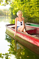 Image showing Woman relaxing on the vintage wooden boat.