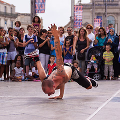 Image showing Street performer breakdancing in front of the random crowd.