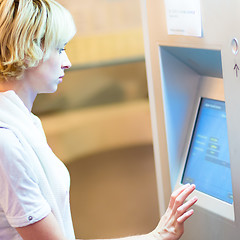 Image showing Lady using ticket vending machine.