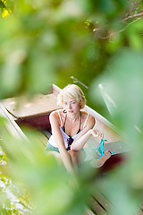 Image showing Woman relaxing on the vintage wooden boat.