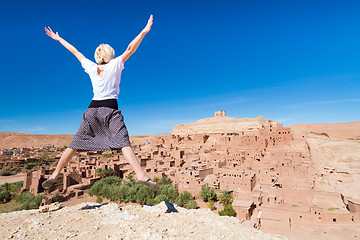 Image showing Traveler jumpin in front of Ait Benhaddou, Morocco.