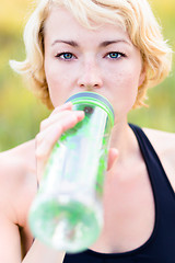 Image showing Portrait of woman drinking water outdoor.