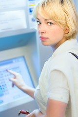 Image showing Lady buying a ticket at the vending machine