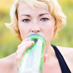 Image showing Portrait of woman drinking water outdoor.