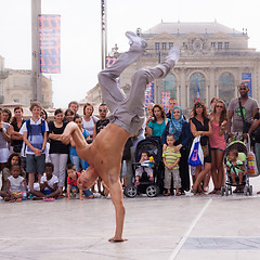 Image showing Street performer breakdancing in front of the random crowd.