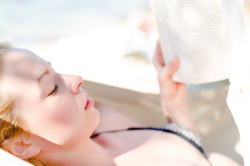 Image showing Lady reading a book in a hammock.