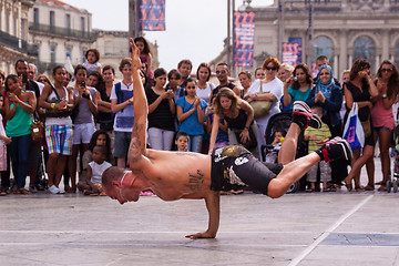 Image showing Street performer breakdancing in front of the random crowd.