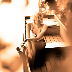 Image showing Woman relaxing on the vintage wooden boat.