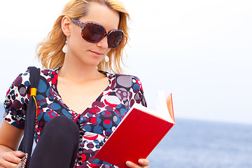 Image showing Attractive young lady reading a book.