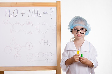 Image showing Chemist girl in points and with the tubes at board