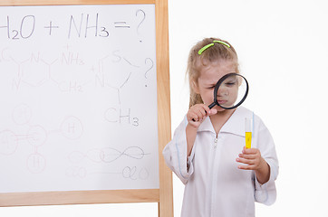 Image showing Chemist closely examines the liquid in a test tube