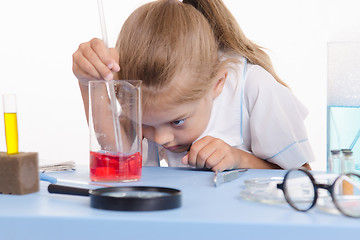 Image showing Chemist looking at the liquid in flask