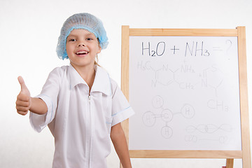 Image showing Chemist girl stands at the blackboard and shows class