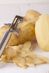 Image showing Potatoes with Peeler and Peeled Skin